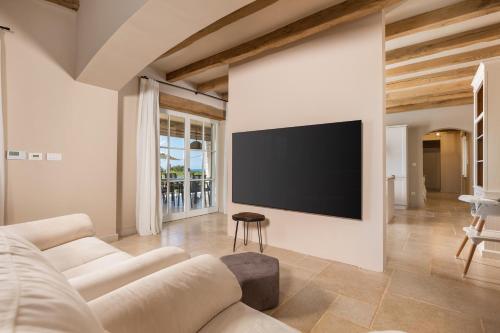 a living room with a couch and a flat screen tv at Villa Plava with Panoramic Seaview and big pool in Bale