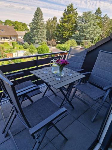 a table and chairs on a balcony with flowers at Moderne Wohnung in Zülpich in Zülpich