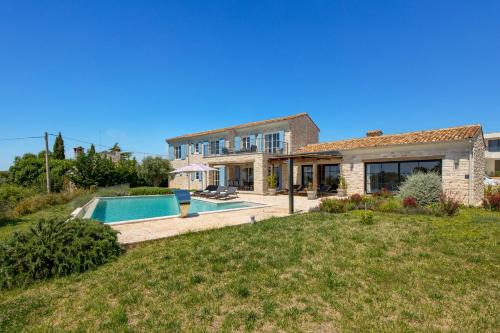 a house with a swimming pool in a yard at Villa Plava with Panoramic Seaview and big pool in Bale