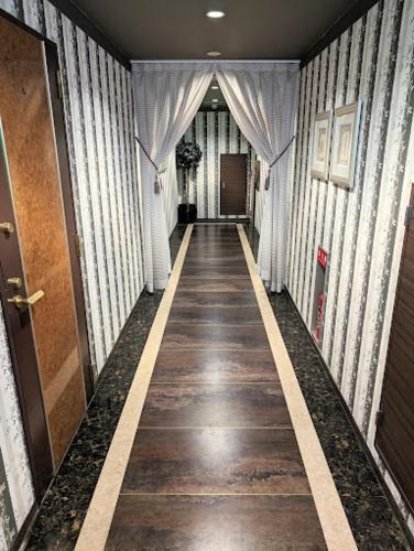 a hallway of a building with a long corridor at もしもしピエロ 泉大津新館 in Izumiotsu