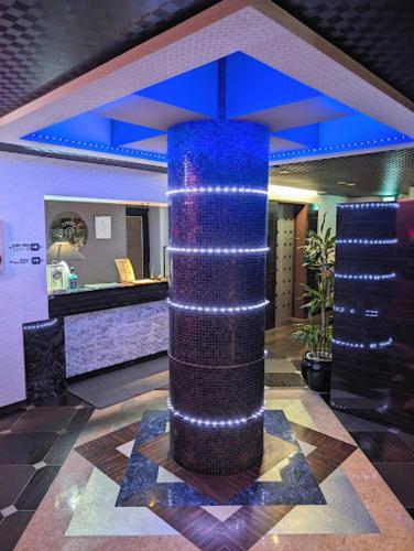 a large blue column with lights on it in a lobby at もしもしピエロ 泉大津新館 in Izumiotsu