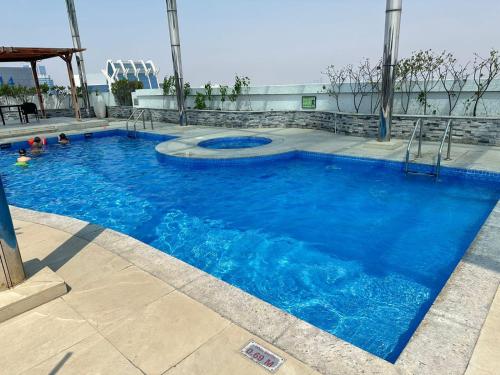 a large pool with blue water in a building at Newly furnished 1 Bedroom, high floor, amazing view, close to metro in Dubai