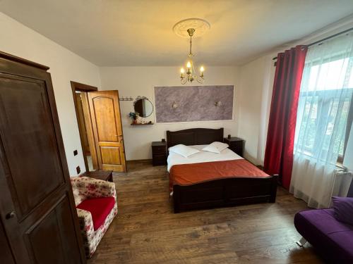 un dormitorio con una cama y una silla en Pensiunea Casa Rica Calimanesti Caciulata, en Călimăneşti