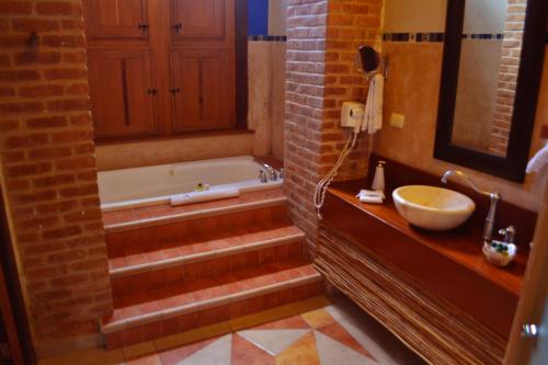 a bathroom with a bath tub and a sink at Hotel Boutique Casa San Angel in Mérida