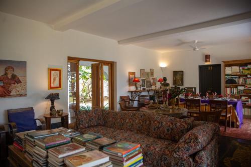 a living room with a couch and a table with books at Isla's Ridge - A CGH Earth SAHA Experience in Kodaikānāl