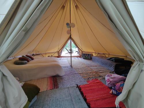 a tent with a bunch of beds in it at Käkiniitty Glamping Cuckoo Camp in Tammela
