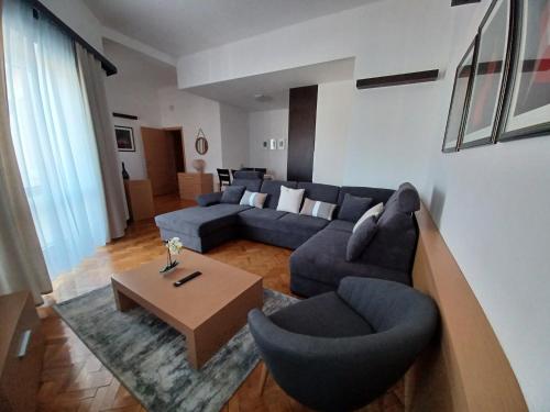 a living room with a blue couch and a table at Apartment ACI Marina CRES in Cres