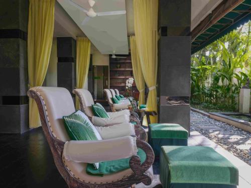 a row of wicker chairs sitting on a porch at Blu-Zea Resort by Double-Six in Seminyak
