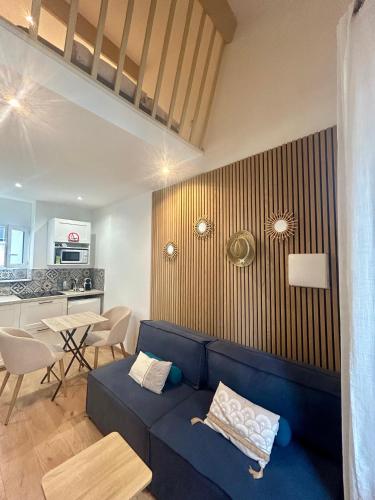 un salon avec un canapé bleu et une cuisine dans l'établissement Le ruisseau, à Nice