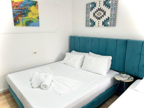 a bed with a blue headboard in a room at Tirana Square Hotel in Tirana