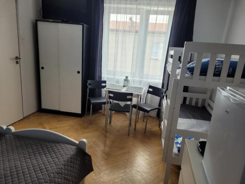 a bedroom with a bed and a table and chairs at Pokoje Gościnne Galeon w Darłówku in Darłowo
