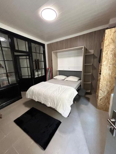 - une chambre avec un grand lit blanc dans une pièce dotée de fenêtres dans l'établissement petit Muguet, à Avignon