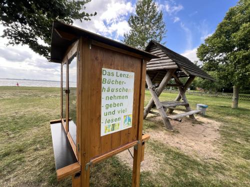 a wooden sign in a field with a building at Zum ehemaligen Kaffeekännchen in Funfseen