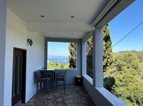 a balcony with a table and chairs and a large window at Holiday Home Aldo in Rogač