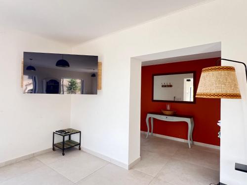 une pièce avec un mur rouge, une table et un miroir dans l'établissement Villa avec vue exceptionnelle, à Sorède