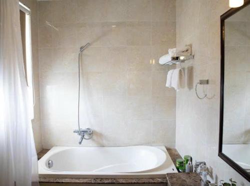 a white bath tub in a bathroom with a mirror at Felix Alley in Ho Chi Minh City