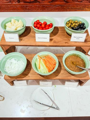 a display of bowls of vegetables and other foods at Le Charme Vientiane Hotel in Vientiane
