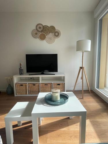 a living room with a coffee table and a tv at T2 Suresnes Proche La Défense Paris Parking Fibre in Suresnes