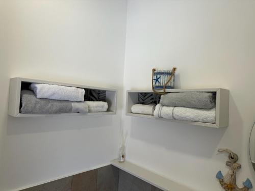a bathroom with two shelves filled with towels at H2O TROPEA in Tropea