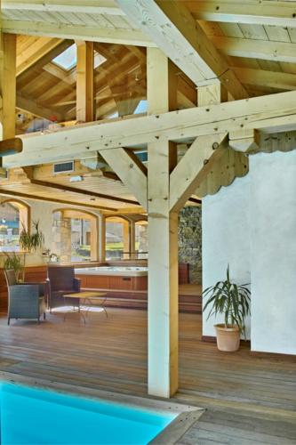 - une terrasse en bois avec une piscine dans une maison dans l'établissement Le Morillon - Piscine et Spa, à Morillon