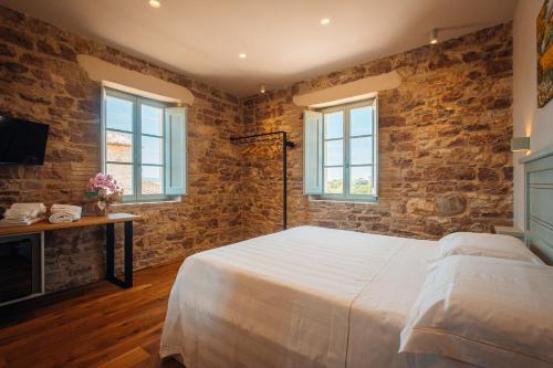a bedroom with a white bed and brick walls at Agriturismo Molinella in Assisi