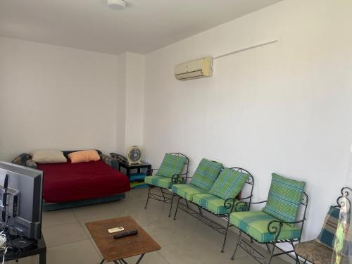 a living room with a bed and chairs and a tv at Lovely penthouse 4- bedroom directly on the lagoon in El Alamein