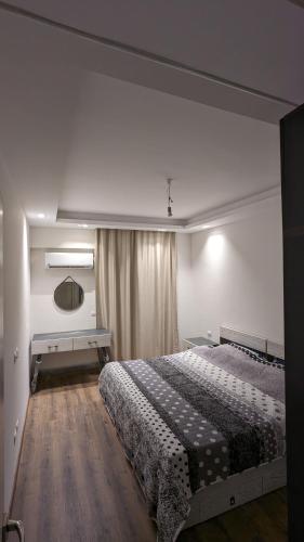 a bedroom with a large bed and a mirror at New Cairo Serviced Apartment in Cairo