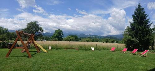 a group of chairs and a playground in a field at Apartma Lida 1 in Bled