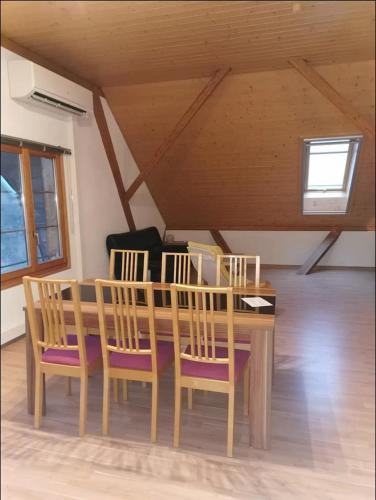 a wooden dining room table with chairs and a window at Privater Whirlpool & Sauna - Wellness Oase in Rüeggisberg