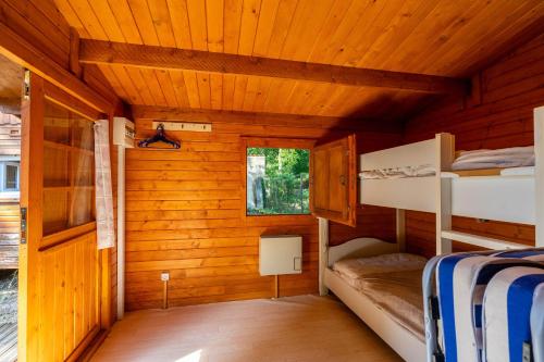 - une chambre avec des lits superposés dans une cabane en bois dans l'établissement Mh16 La Tremblade, à La Tremblade