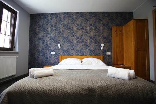 a bedroom with a large bed with blue wallpaper at Dom Pielgrzyma w Kodniu in Kodeń