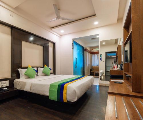a bedroom with a large bed with green pillows at Treebo Westview in Vapi