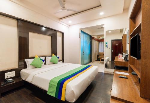 a bedroom with a large bed and a television at Treebo Westview in Vapi
