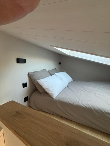 - un lit dans une chambre sous un toit dans l'établissement Charmante maisonnette à Angoulins, à Angoulins-sur-Mer