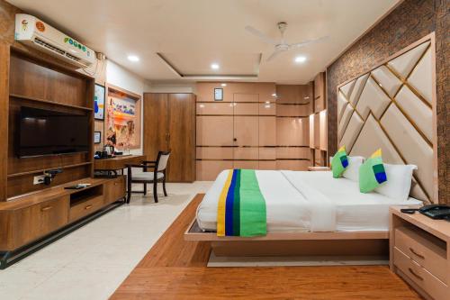 a bedroom with a large bed and a desk at Treebo Westview in Vapi