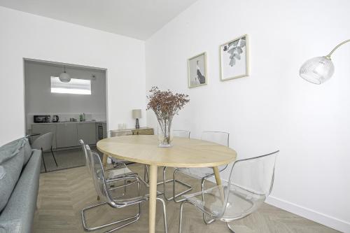 - une table à manger avec des chaises et un vase fleuri dans l'établissement Appartement F4 - Palais de justice - Proche gare, au Havre