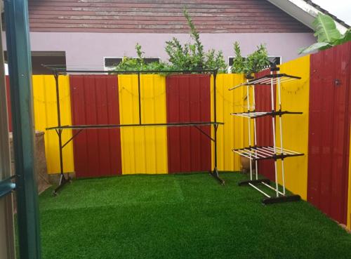 a backyard with a colorful fence and green grass at Hana Homestay Kolam Terengganu in Marang