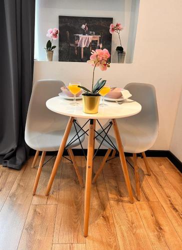 a table with two chairs and a table with flowers on it at Nice 1Room Condo WarszawaCenter in Warsaw