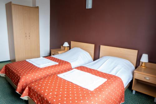 two beds sitting next to each other in a room at Hotel Wilanów in Warsaw