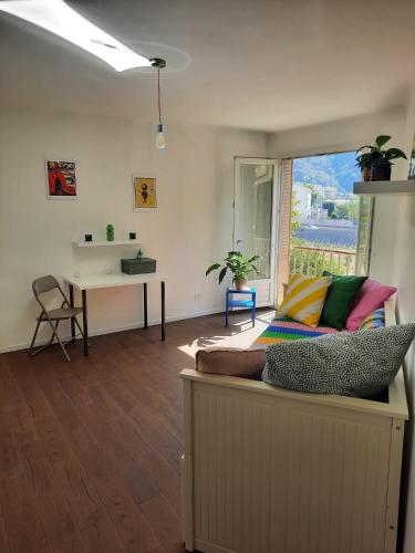 un salon avec un canapé et un bureau dans l'établissement La Chambre 1, Climatisée AC, Cuisine privée, à Nice