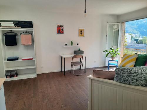 un salon avec une table et un bureau dans l'établissement La Chambre 1, Climatisée AC, Cuisine privée, à Nice