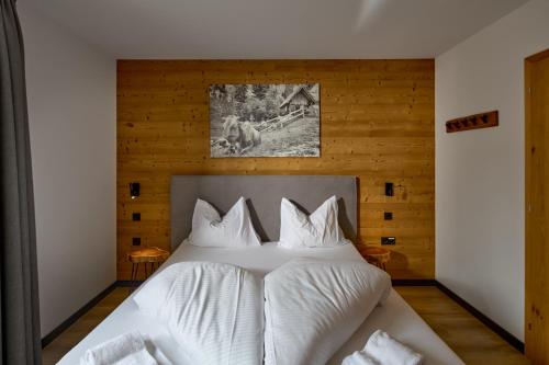 a bedroom with a large bed with white sheets at Camp Exklusiv - Alpin-Resort Montafon Haus 2 by Pferd auf Wolke in Gargellen