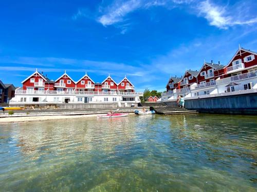 a row of red and white buildings on the water at Luxury Holiday Home With Sea View in Gråsten