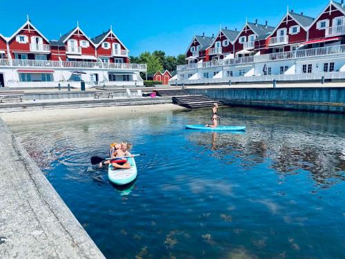 a group of people in kayaks in a river with houses at Luxury Holiday Home With Sea View in Gråsten