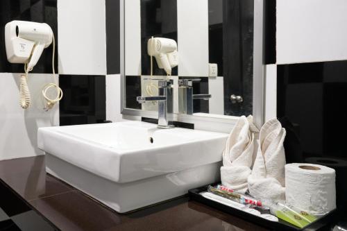 Un baño con un lavabo blanco y un espejo. en Tan Sokchea Boutique, en Siem Reap