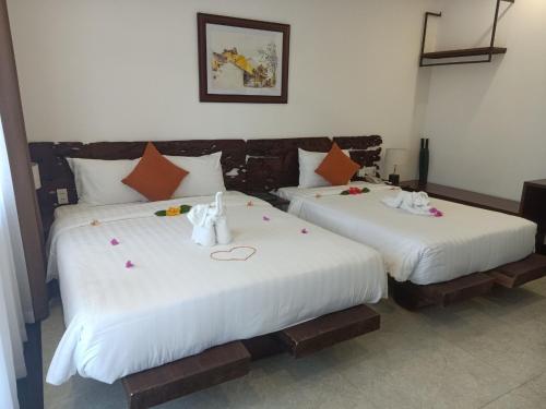 two beds with stuffed animals on them in a room at Mayci Boutique Hotel & Restaurant by Amber in Hoi An