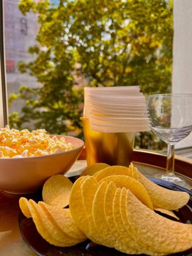 a plate of crisps and a bowl of chips and a glass at Nice 1Room Condo WarszawaCenter in Warsaw