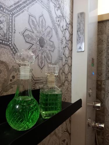 two green glass bottles sitting on a shelf at Masseria Petra in Martano