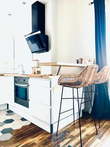 une cuisine avec un comptoir, une cuisinière et une chaise dans l'établissement La Garenne Colombes proche La Défense et idéal Jeux Olympiques, à La Garenne-Colombes