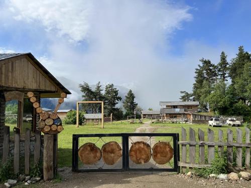 a fence with logs on it next to a field at Heshkili huts and cabins Svaneti in Keshkili
